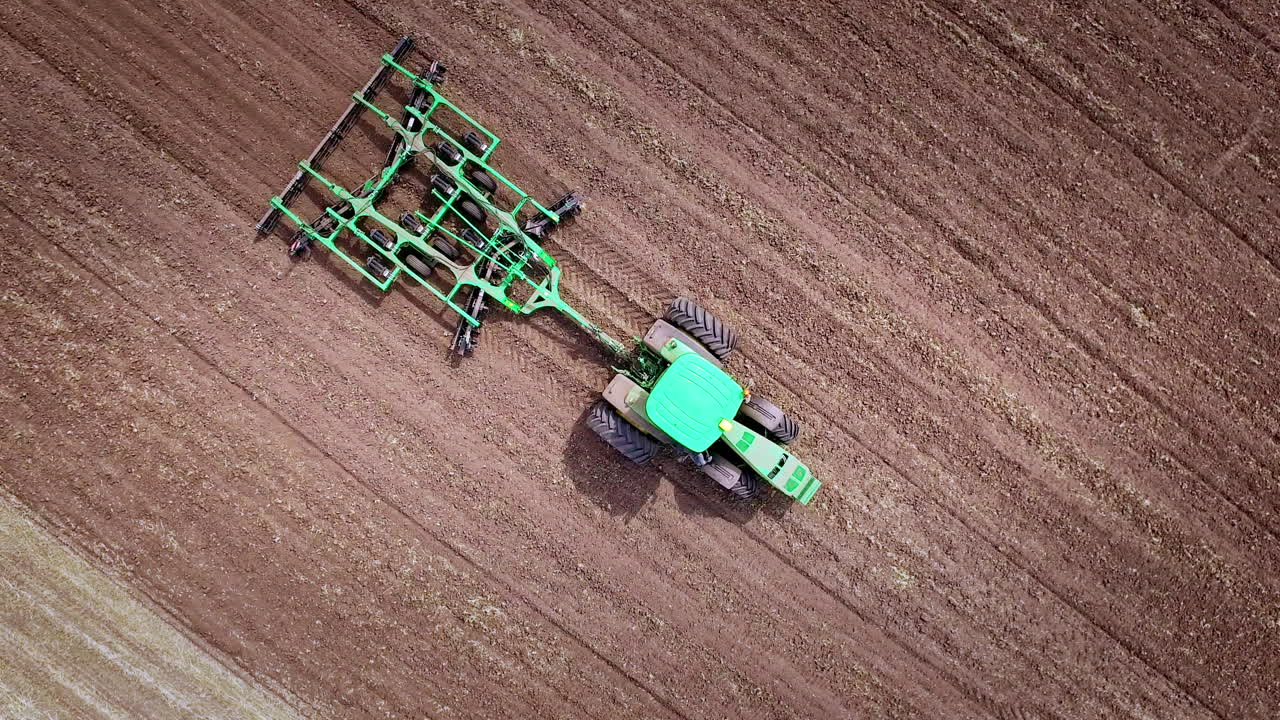 tractor agrícola arando el campo de cultivo. vista aérea de la maquinaria agrícola
