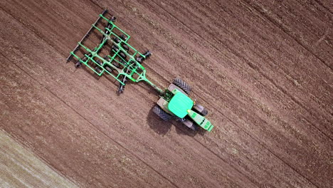 Agricultural-tractor-plowing-arable-field.-Aerial-view-of-agriculture-machinery