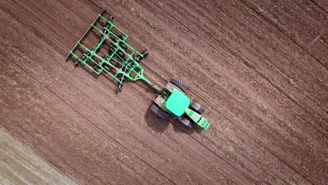 tractor agrícola arando el campo de cultivo. vista aérea de la maquinaria agrícola