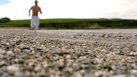 shirtless man jogging by the coast