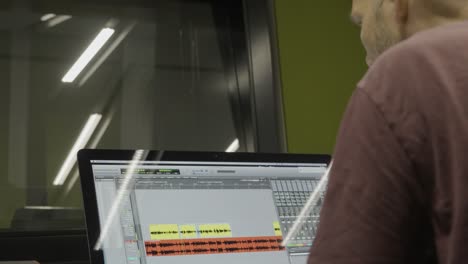 ingeniero de audio anónimo que produce música en un estudio de grabación utilizando software de producción musical