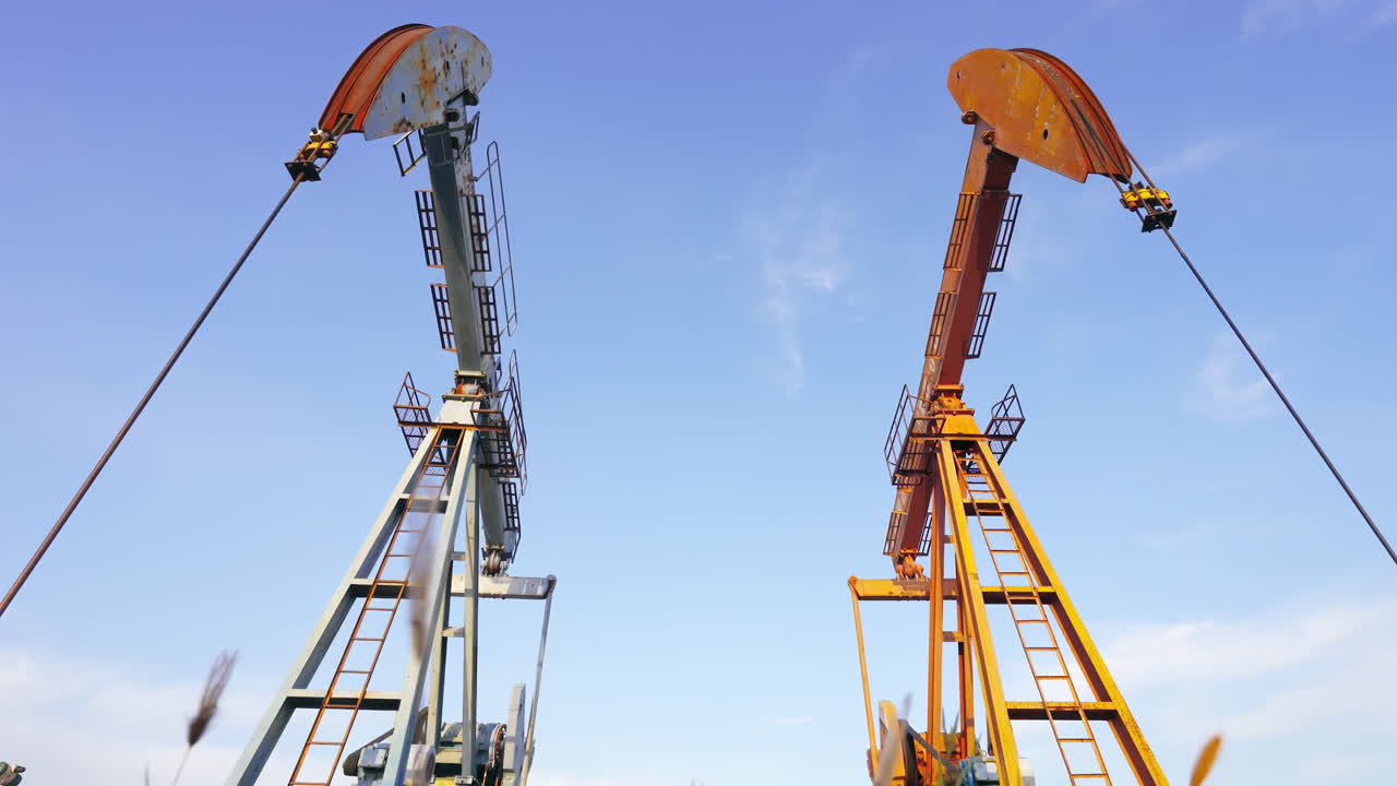 Industrielle borerigge med boretårne til råolieudvinding, oliepumpestationer i drift på oliefelter; kontinuerlig udvinding af fossile brændstoffer til dækning af globalt energiforbrug og efterspørgsel på energiforsyning.