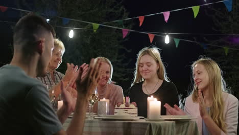 family birthday celebration in the garden at night