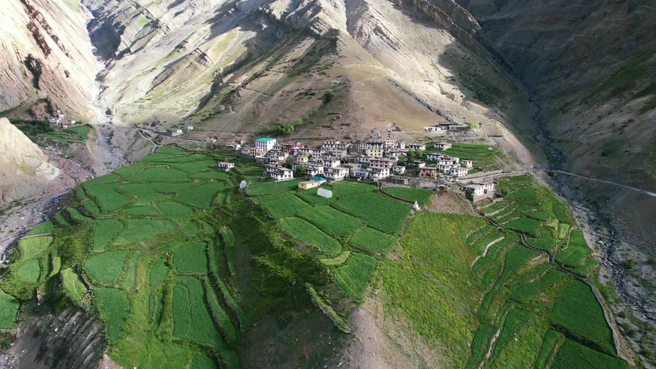 Tibetan mud village in extreme mountain landscape of Pin Valley India on summer day, aerial