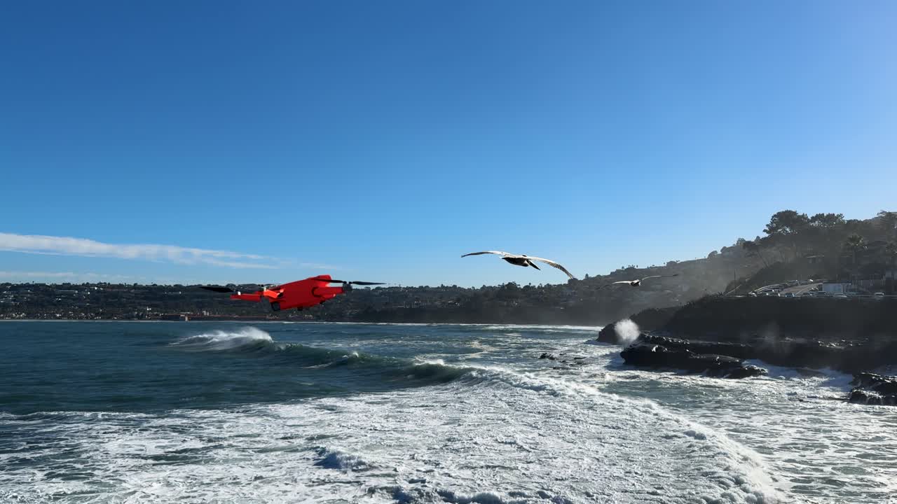 캘리포니아 주 샌디에이고의 라 라 코브 (la jolla cove) 에서 높은 물결 중에 절벽에 부히는 큰 바다 파도와 함께 왼쪽에서 오른쪽으로 날아가는 드론의 4k 영상