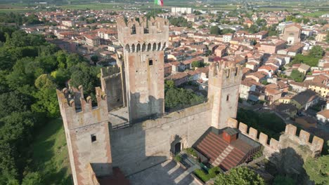 Toma-Aérea-Orbitando-El-Castillo-De-Scaliger-En-El-Pueblo-De-Borghetto,-Cerca-De-Verona.