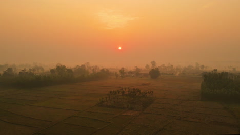 Soar-above-the-enchanting-Bardiya-plains-at-dawn,-as-golden-rays-illuminate-swirling-winter-mists,-unveiling-Nepal's-Terai-in-an-ethereal-drone-spectacle