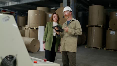 factory workers discussing operations on a tablet