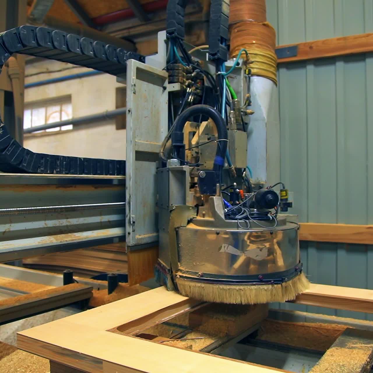 Wooden door manufacturing. Special equipment moving over the timber door billet. Close up