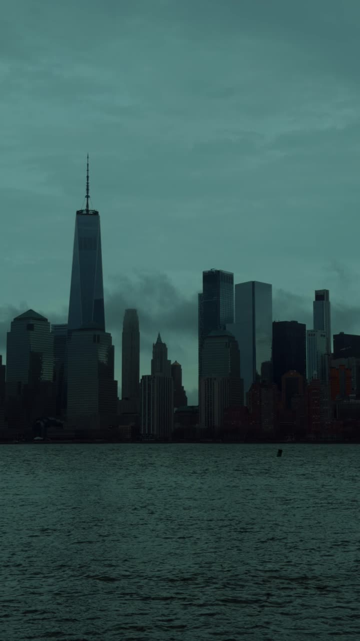 Vista vertical del icónico horizonte de Nueva York y la arquitectura urbana durante la hora azul. Perspectiva de ángulo alto de los rascacielos de Manhattan con las luces de la ciudad parpadeando al anochecer.