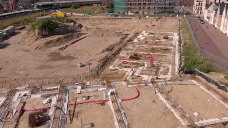 vista aérea ascendente del barrio de noorderhaven que muestra el sitio de construcción de ubuntuplein junto a las vías del tren en el proyecto de inversión inmobiliaria de desarrollo urbano