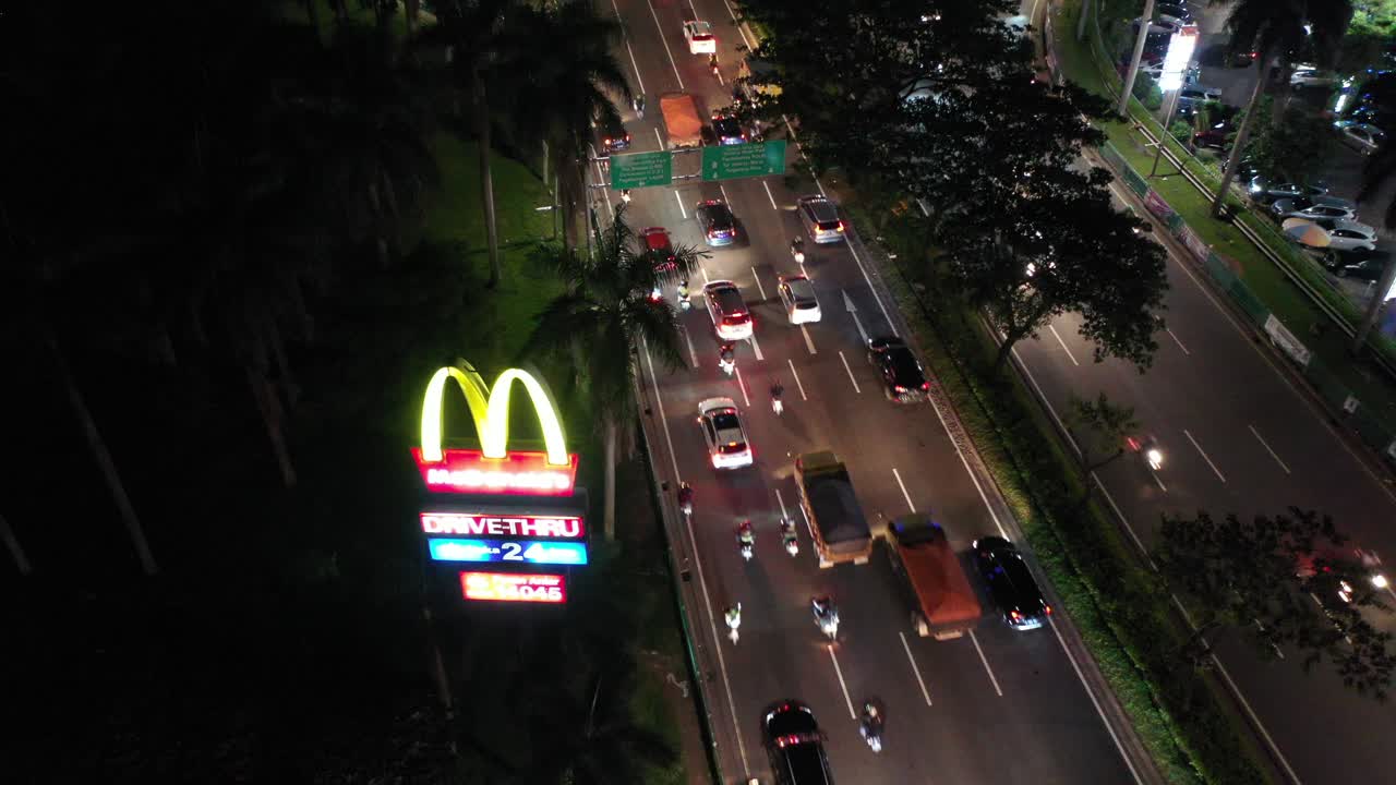 el tráfico nocturno en jakarta con un drive-thru de mcdonald