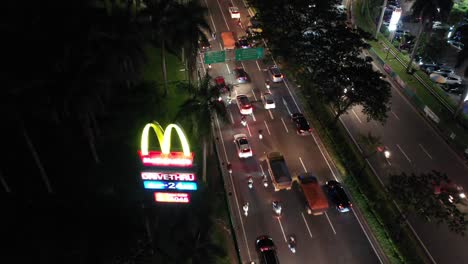 el tráfico nocturno en jakarta con un drive-thru de mcdonald