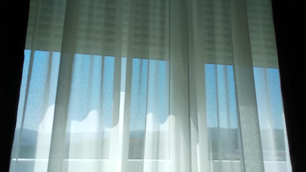 ventana automática con cortinas blancas durante la luz del día
