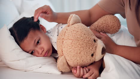 madre, niño enfermo en la cama con un oso de peluche