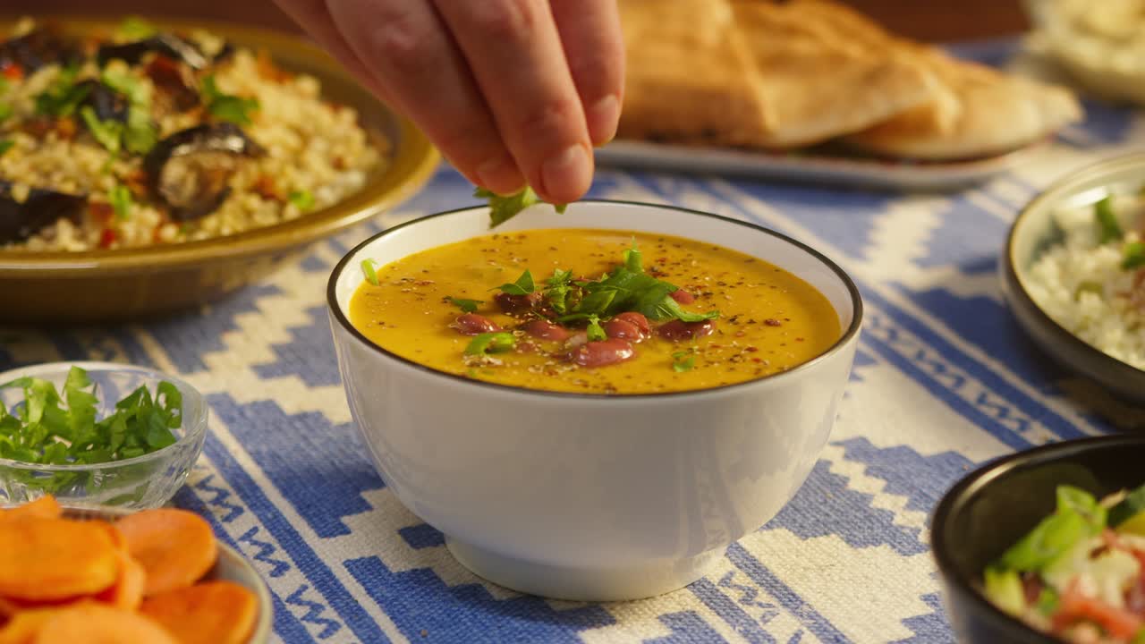 salpicando la verdura en la sopa de frijoles en la mesa de primer plano. cocina árabe. pita y bulgur, cuscús en el fondo. cultura tradicional de oriente medio. delicioso arroz con carne. concepto de comida casera