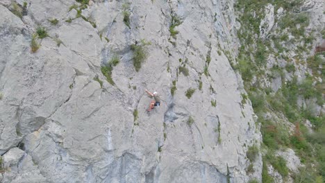 Distant circular drone footage of a man lead climbing in the Pyrenees moutains at Tarascon sur Ari&egrave;ge