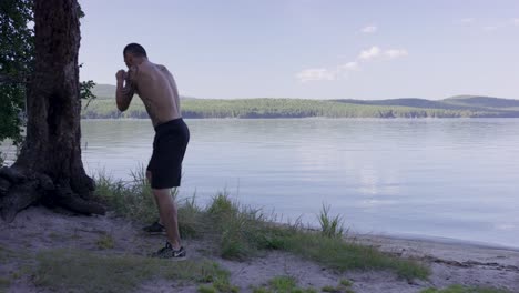 man boxing training by the lake