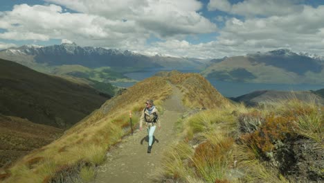 female hiker on ben lomond tiki mountain trail of new zealand, tourist activity