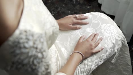 bride with her hands on the knees, dressing the wedding dress