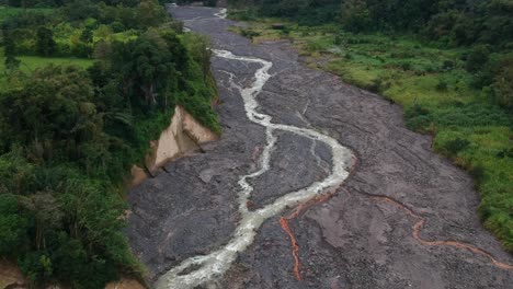 Río-De-Agua-En-Un-Río-De-Lava-Dura-Y-Fría-Cerca-De-Un-Volcán-Sinabung-En-Erupción