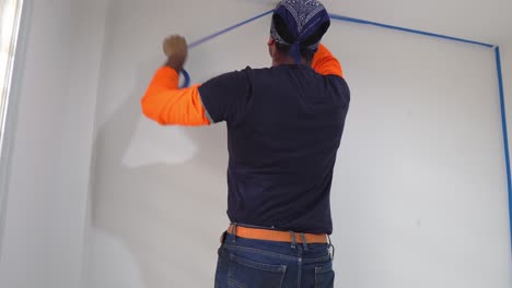 man putting on painter's tape - close up