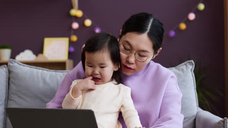 Asiatische-Mutter-Mit-Ihrem-Baby-Im-Wohnzimmer