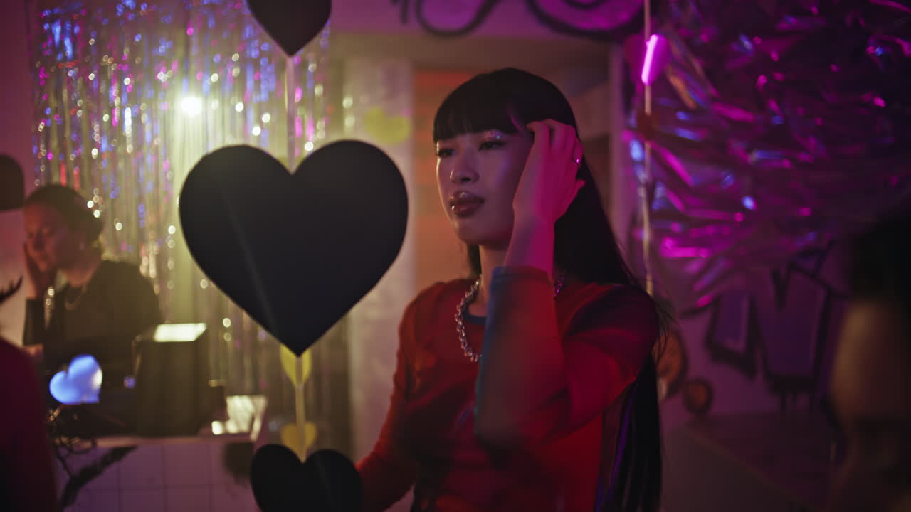 Clubbing friends having fun at colorful lights party closeup. Women dancing