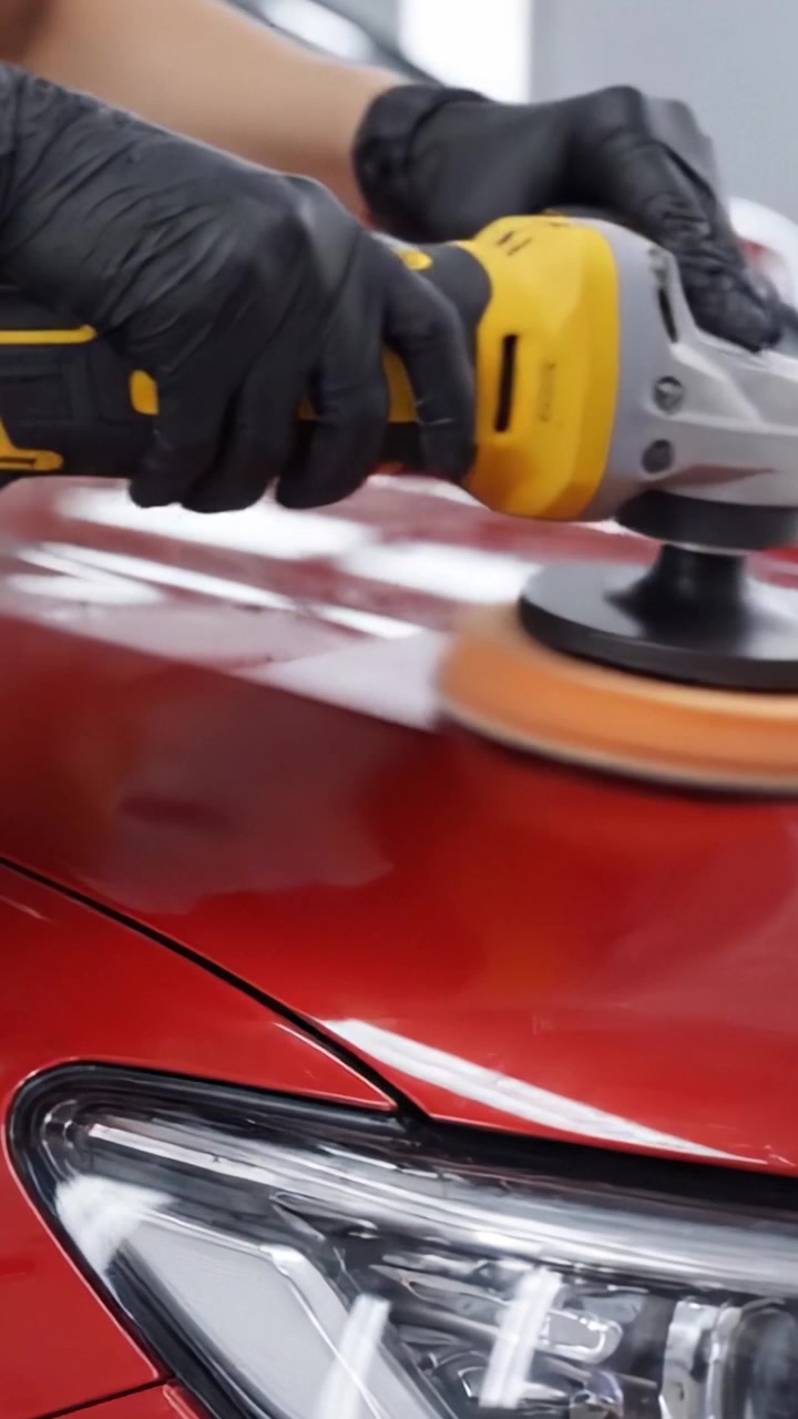 A Close-Up View of a Professional Vehicle Detailing Process Showcasing Polishing on a Glossy Red Car Surface for Enhanced Shine and Protection