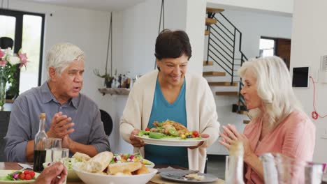 happy senior diverse people having dinner at retirement home