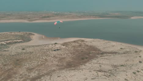 vista aérea volando en parapente motorizado sobrevolando la costa árida junto al lago salado