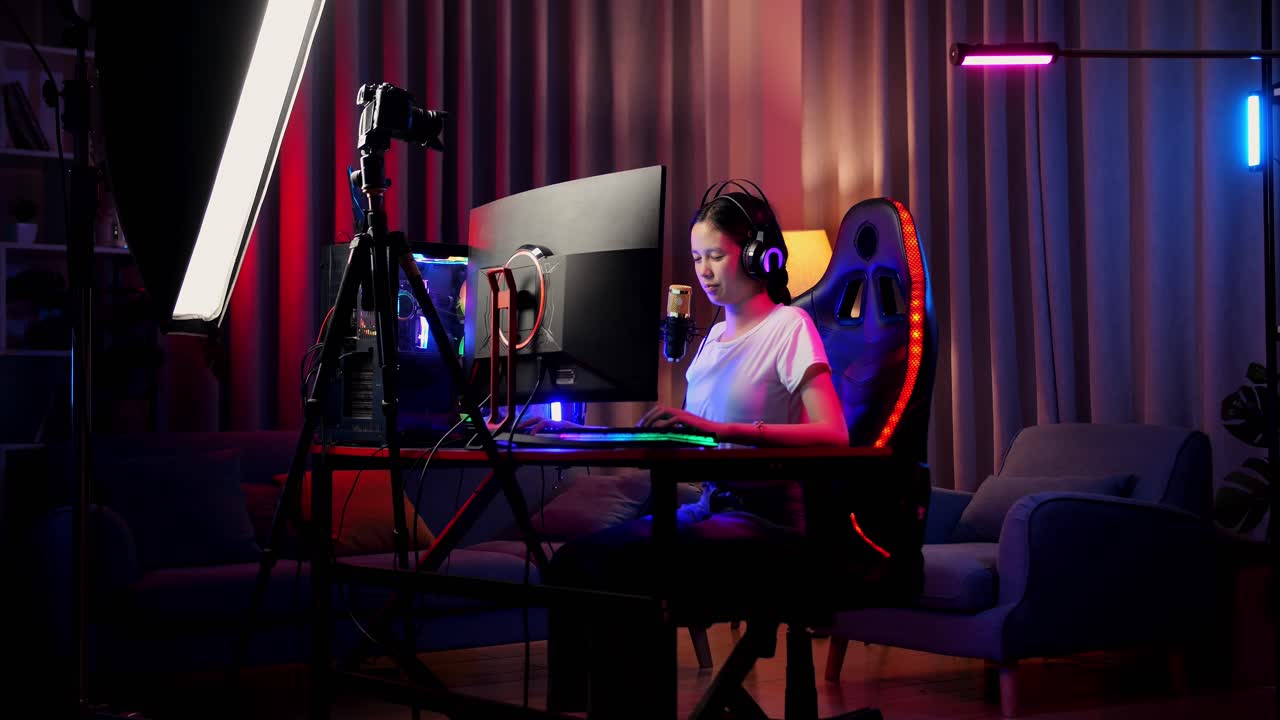 Asian Girl Streamer Having A Backache While Playing Game Over Network On Personal Computer. Live Stream Video Game, Desk Illuminated By Rgb Led Strip Light