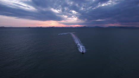 aerial view of jet skis moving toward the drone, dramatic dusk in thailand