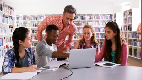 Teacher-assisting-schoolkids-on-laptop-4k