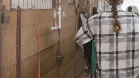 joven con trenza acercándose a su caballo negro