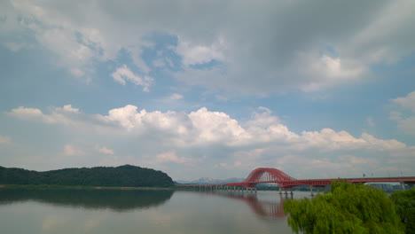 scenic view of a red bridge over a calm river