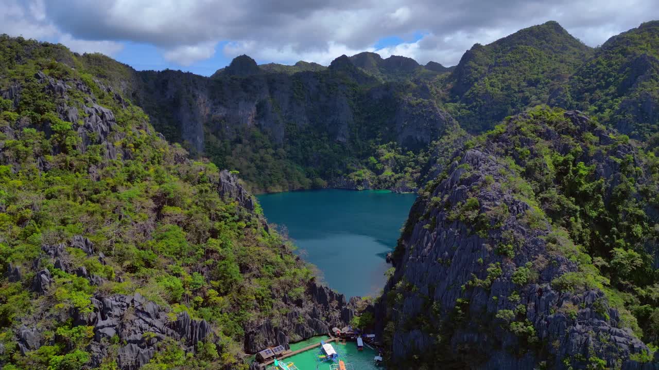 Hồ Barracuda trên đảo Coron, Palawan, mang đến một điểm lặn độc đáo. Thảm thực vật xanh tươi bao phủ những vách đá vôi cao bao quanh làn nước xanh thẳm. Góc nhìn toàn cảnh tuyệt đẹp từ trên cao, đang bay lên và mở rộng