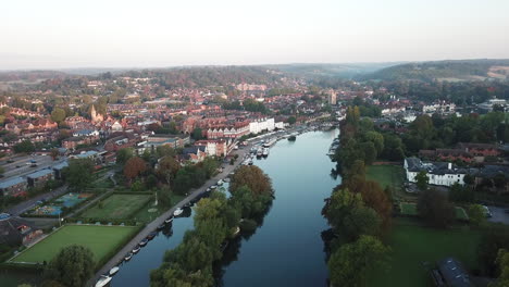 beautiful morning drone shot of henley on thames, panning high above the river and moving towards the town from the west