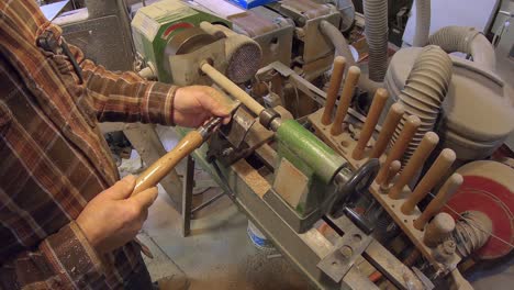 making wooden dowel rod on turning wooden lathe with chisel