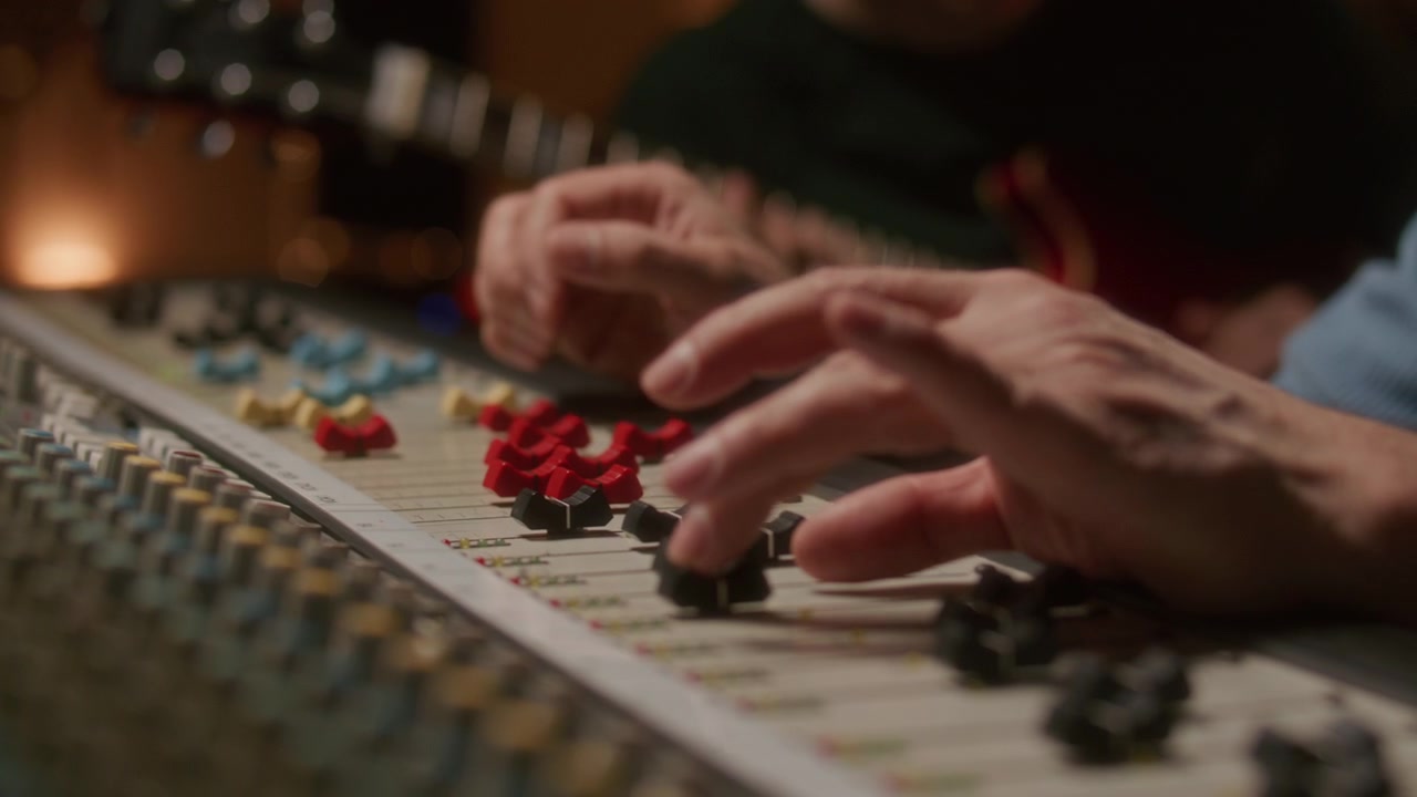 Close Up of Hands of Sound Engineer Adjusting Faders on Mixing Console