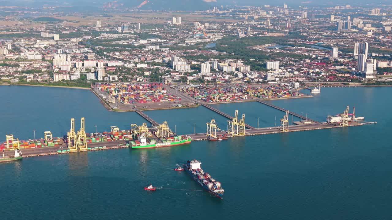 Zoomed in drone shot of container terminal port in Butterworth, Penang, Malaysia with cargo ships, cranes, and logistics activity, global trade, shipping industry, and maritime infrastructure