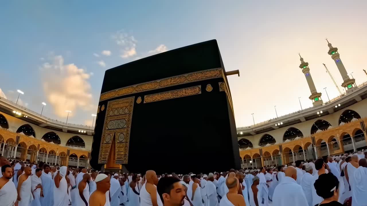 Vídeo de gran angular que captura a peregrinos alrededor de la Kaaba al atardecer y que enfatiza la espiritualidad.