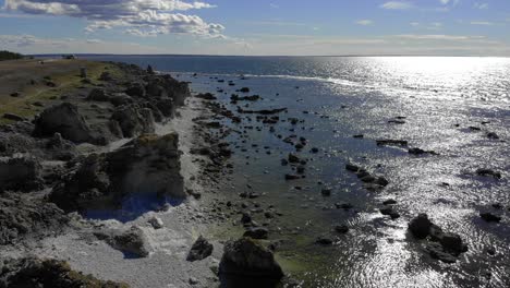 Hermosa-Playa-De-Rauk-Con-Sol-Reflejado-En-La-Superficie-Del-Agua,-Antena-Delantera