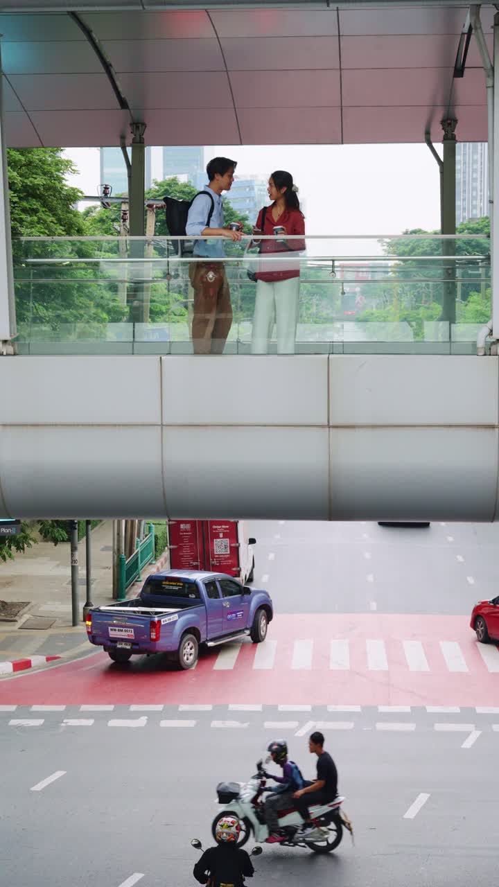 People on pedestrian bridge and traffic on road