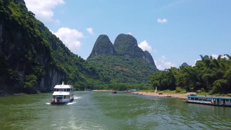 sightseeing boat full of tourists departing on a trip on the magnificent li river from guilin to yangshuo, china