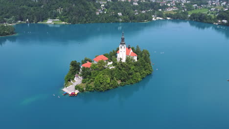 Vista-Aérea:-Crucero-En-Barco-E-Isla-Con-Iglesia-En-El-Lago-Bled,-Eslovenia