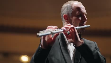 professional musician is playing flute in opera house or philharmonic hall portrait of flutist in orchestra