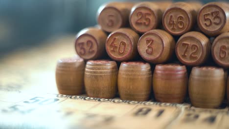 amazing creative smooth dreamy macro shot of bingo wooden barrels in a row, woody figures, old numbers background, vintage board game, slow motion 120 fps commercial gimbal video, crane movement