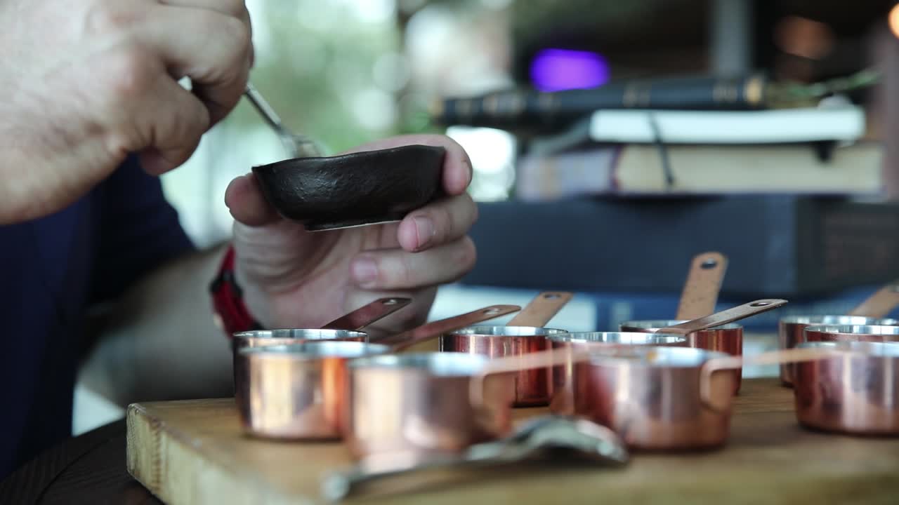 작은 구리 컵 에 향신료 를 맛보는 요리사
