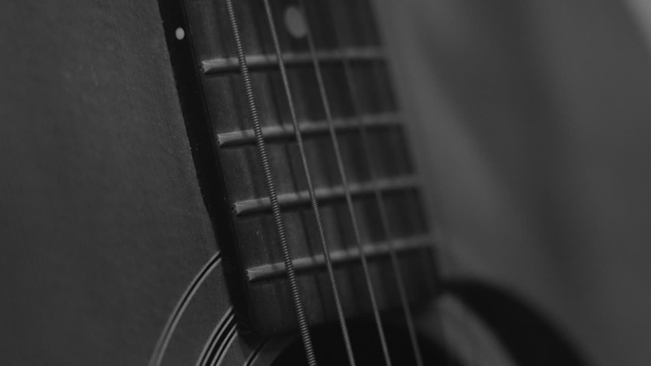 movimiento lento extremo de una cuerda de guitarra arrancando en blanco y negro